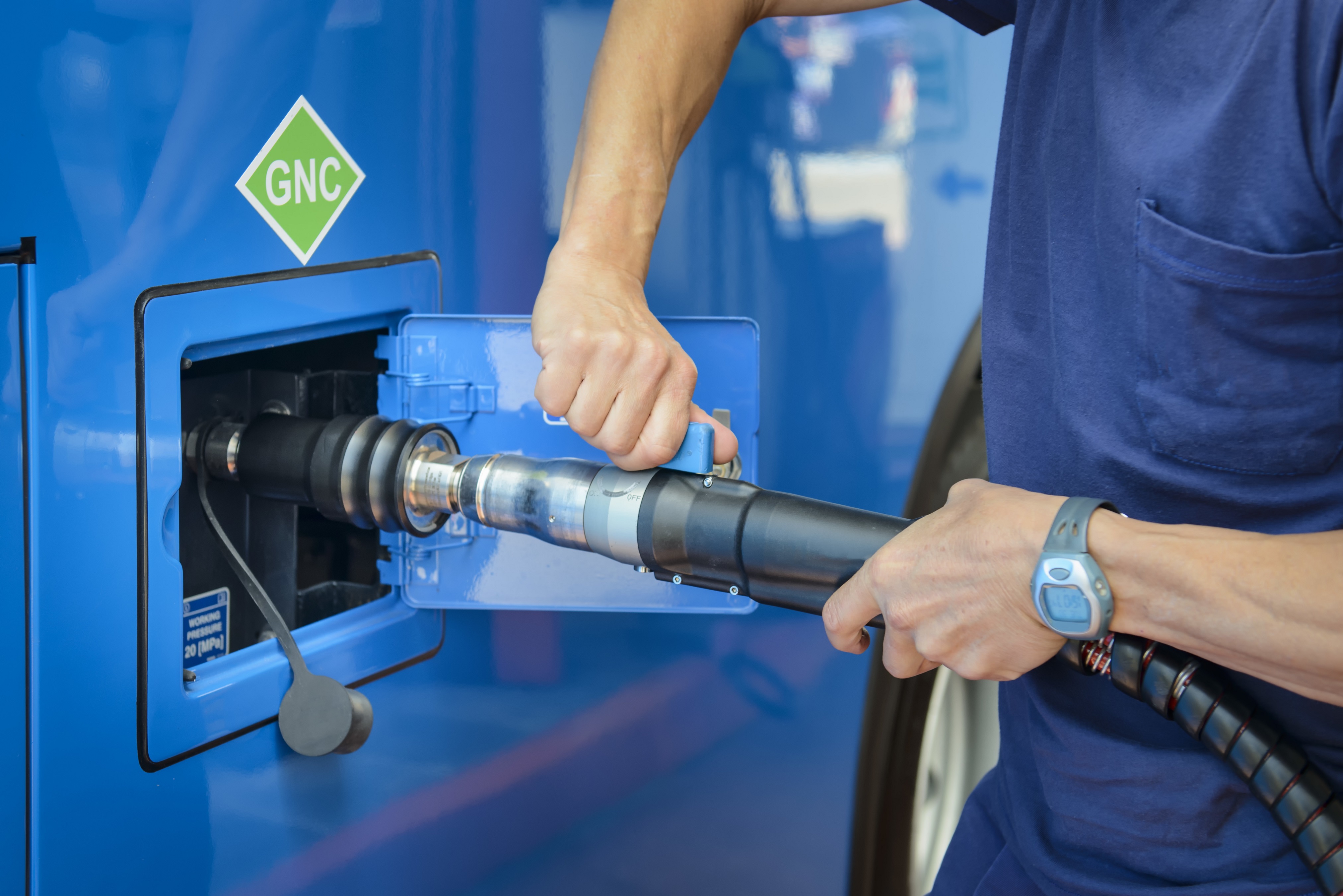 Man using a hose fitting to transfer liquid.